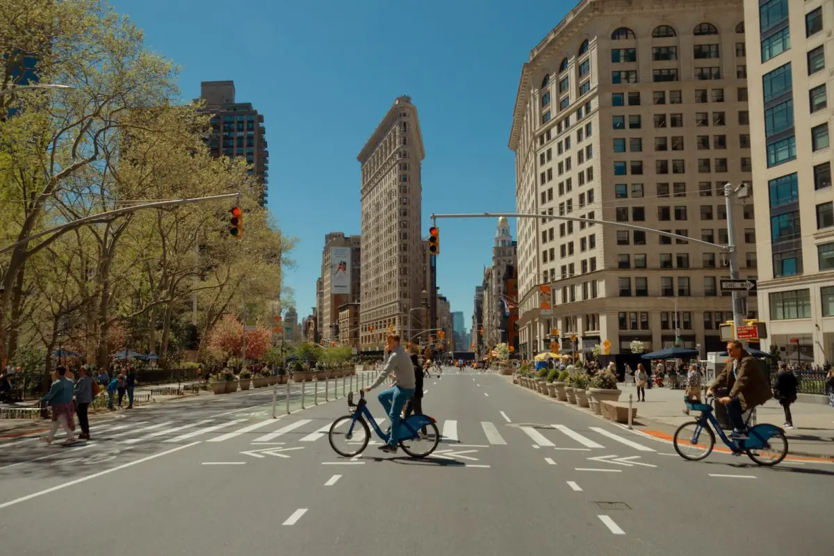 man in black jacket riding on black bicycle on road during daytime