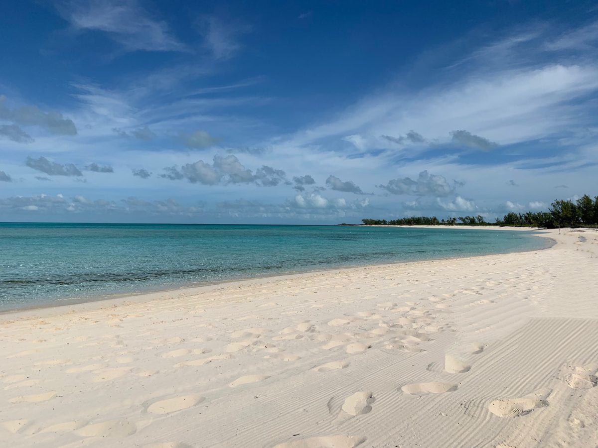 white sand beach under blue sky and white clouds during daytime